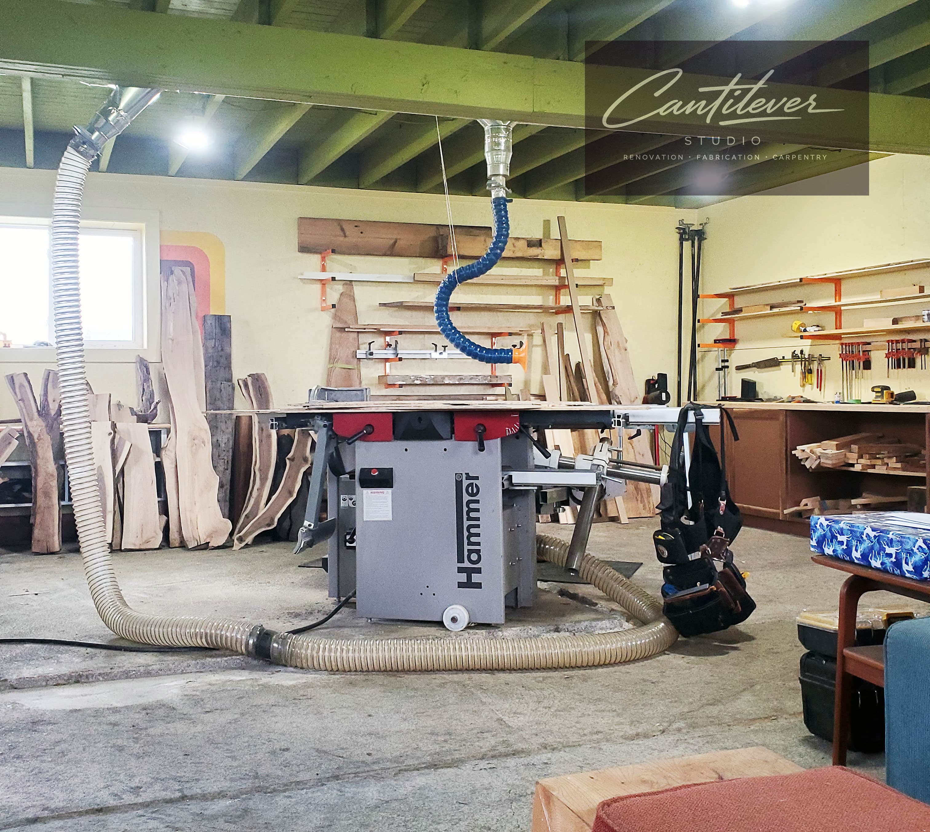 Cantilever Studio workshop with lumber, tools, and shop fabrication equipment.