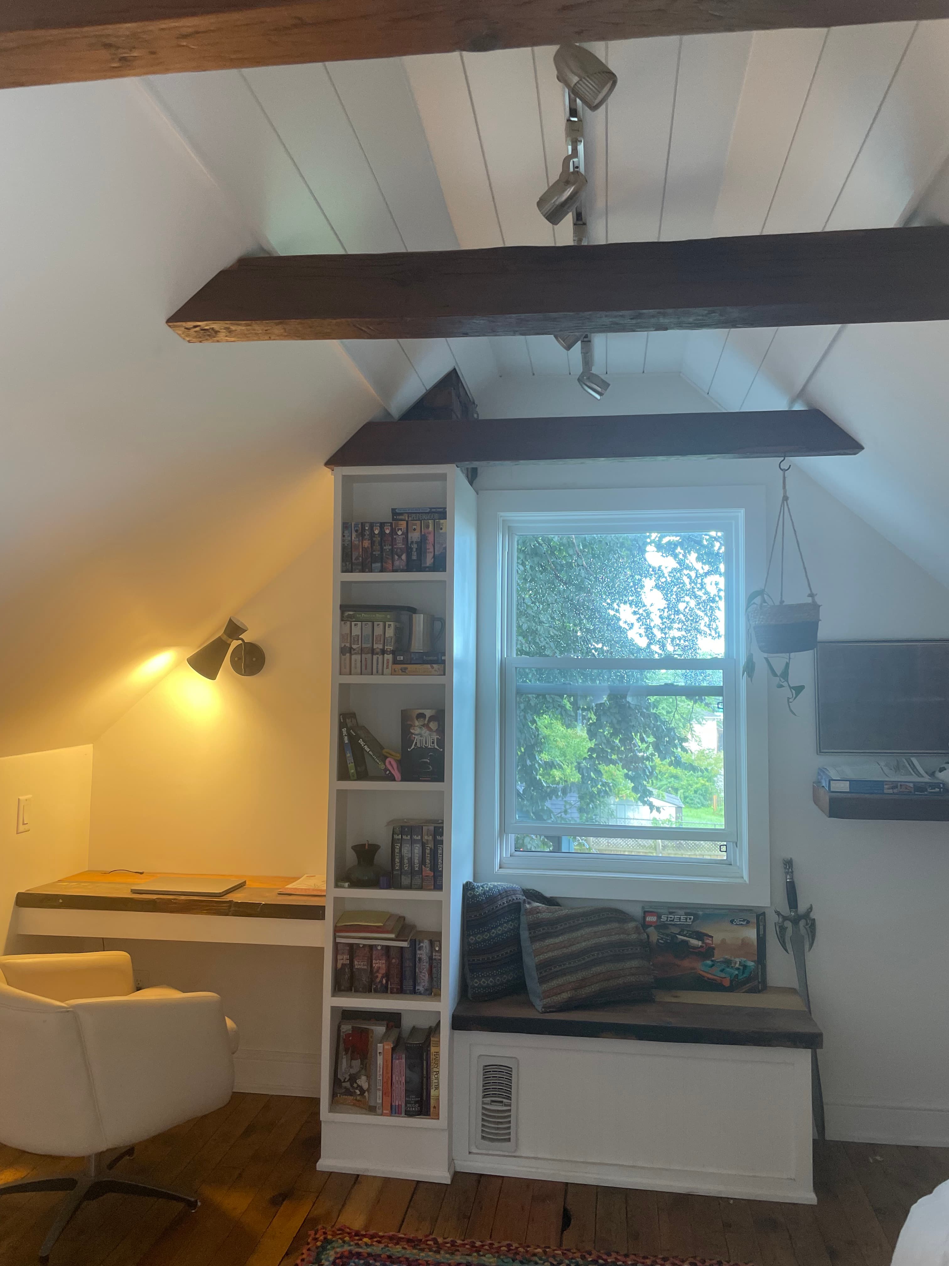 Finished attic built-in shelving and window bench under a sloped ceiling.
