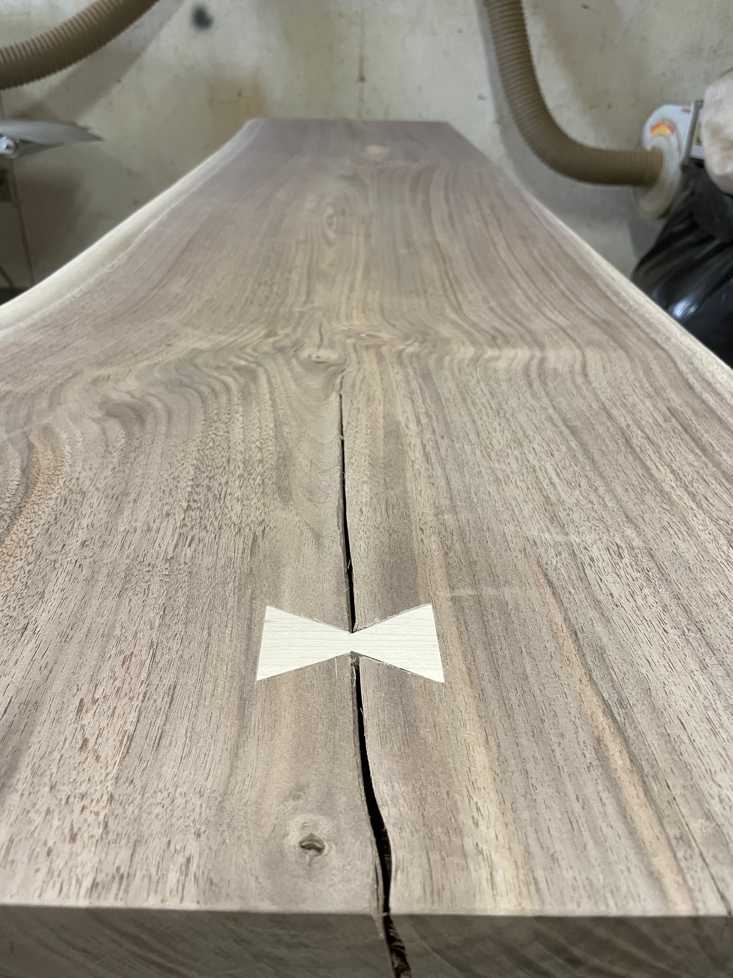 Walnut slab with a light butterfly key set across a split.