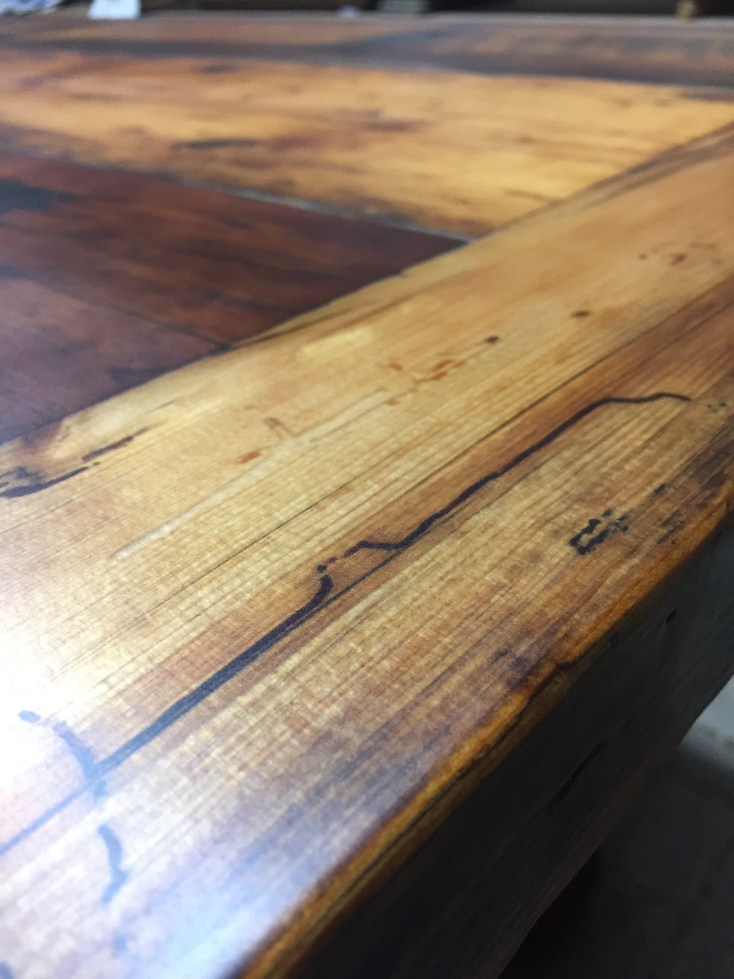 Reclaimed wood table detail with a dark epoxy channel.