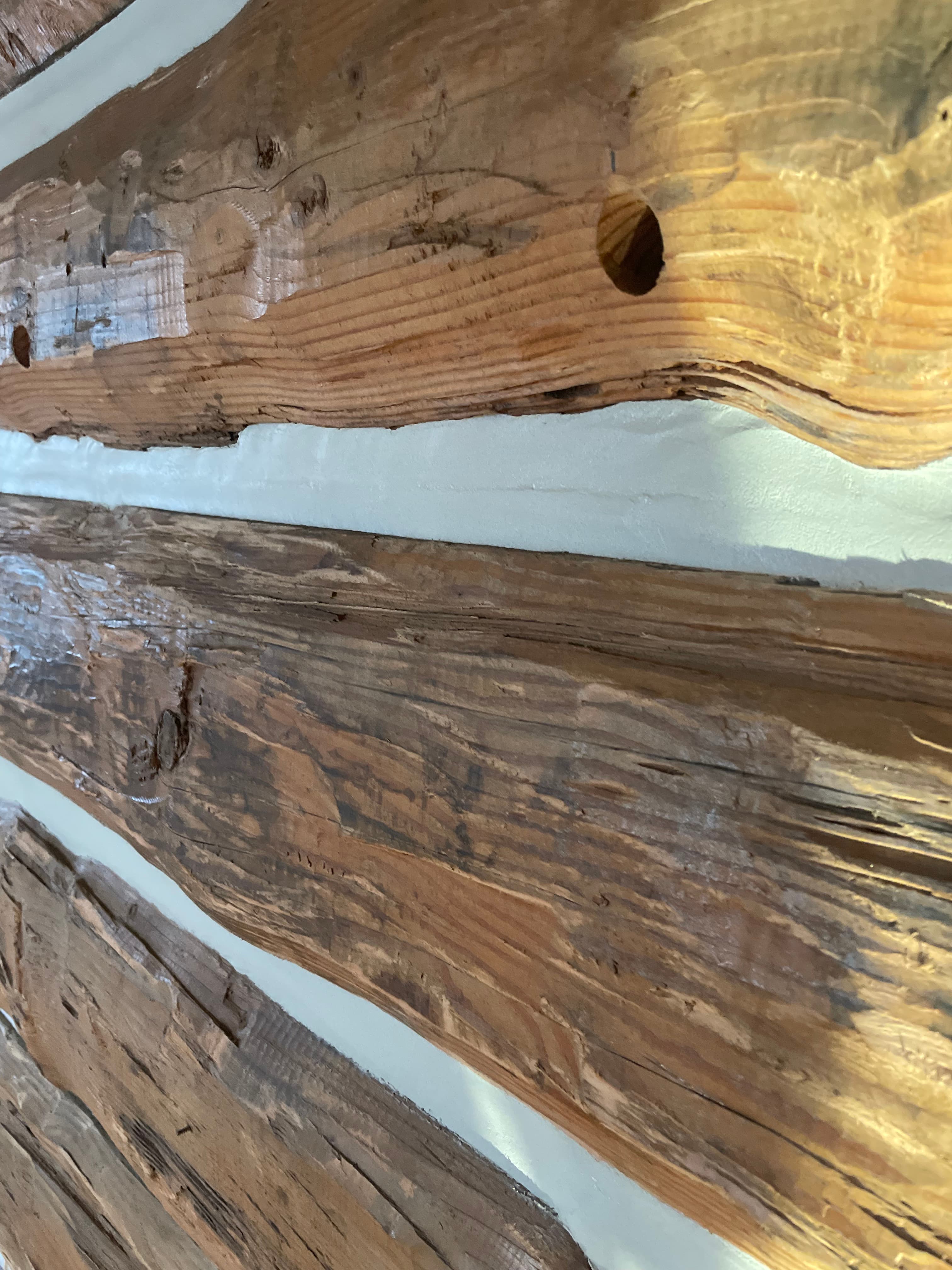 Close detail of chinking between weathered log timbers.