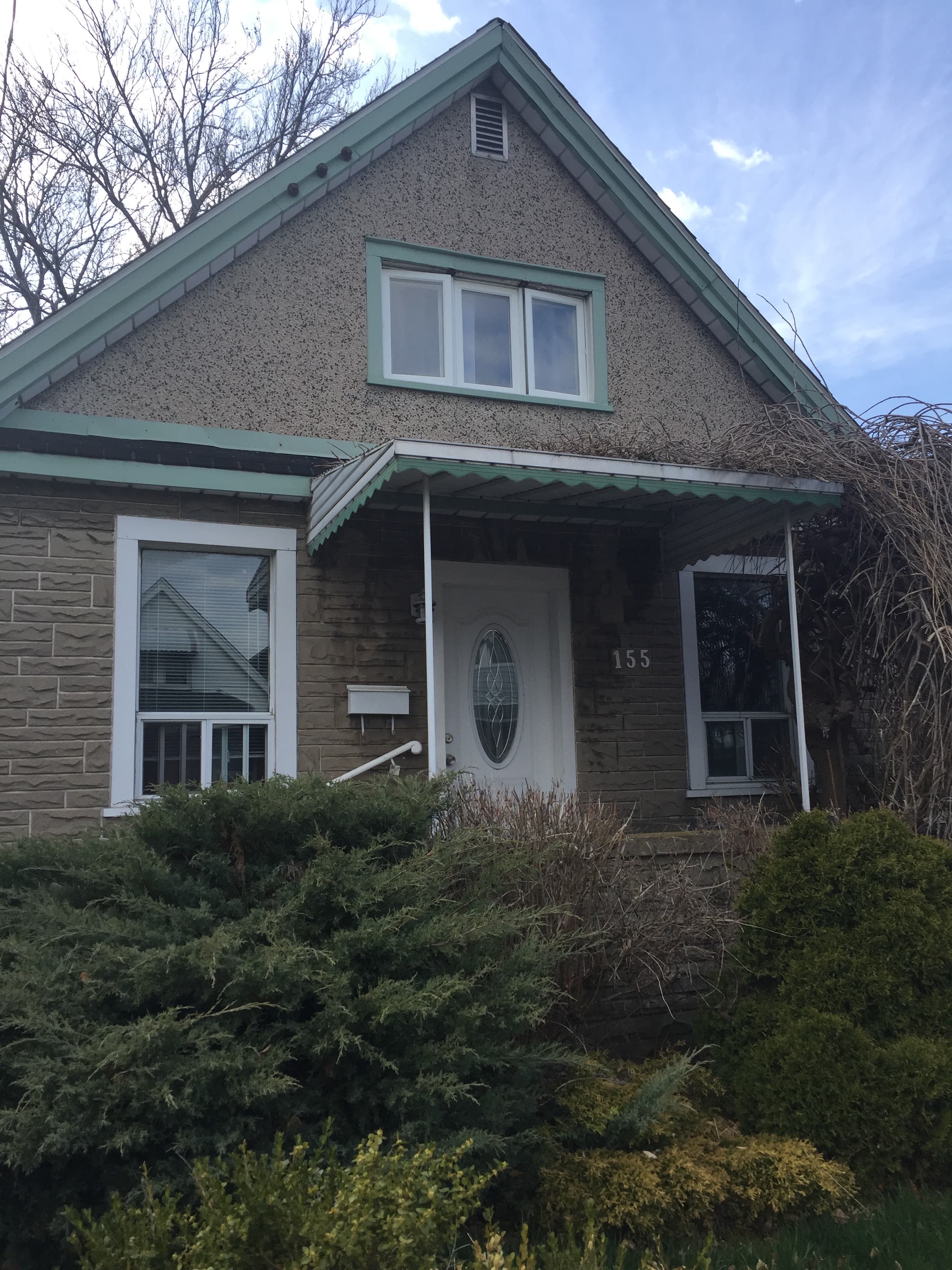 House facade before exterior renovation, with older siding and entry conditions.