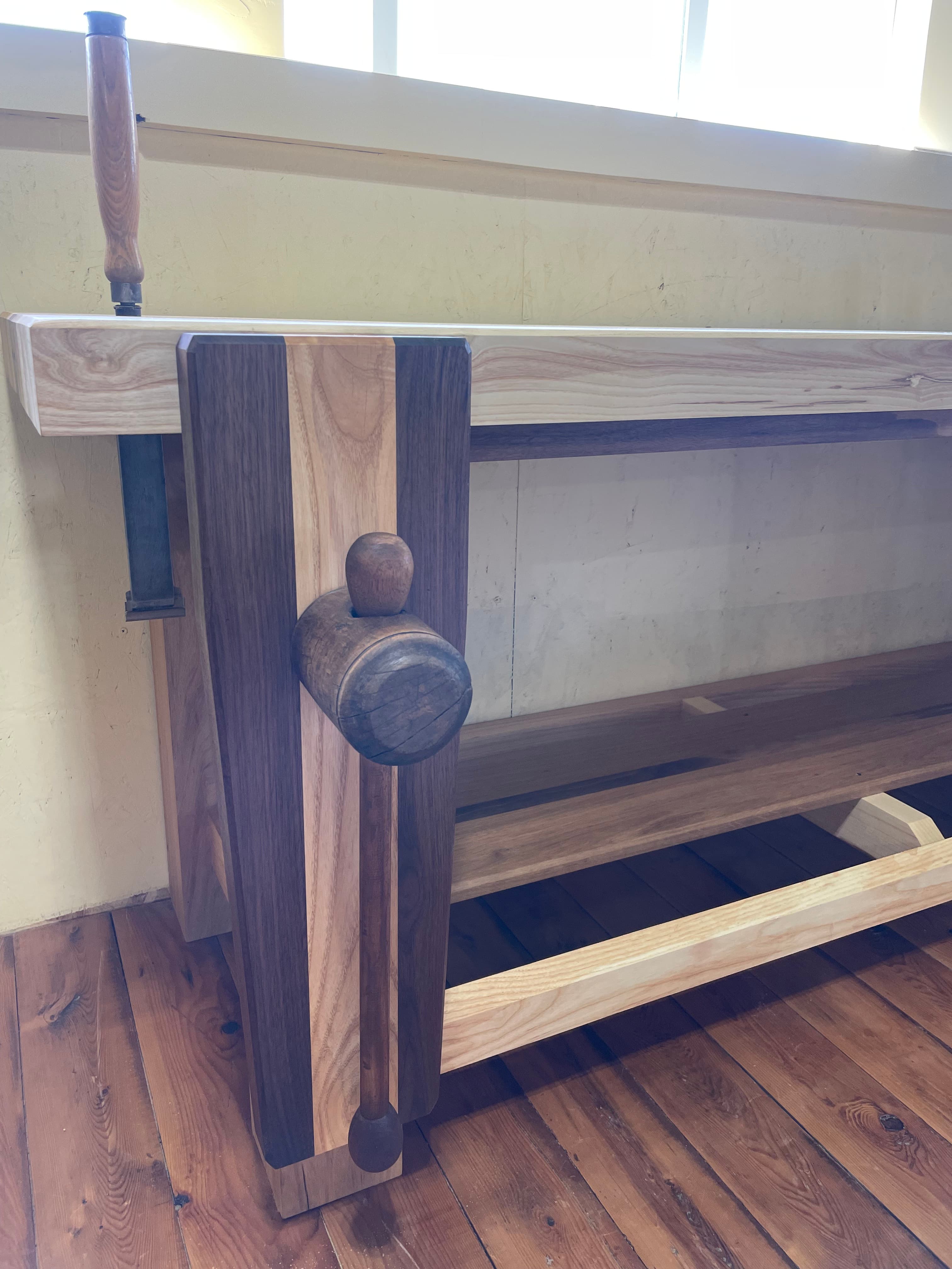 Walnut and ash bench detail with a round rail and contrasting boards.