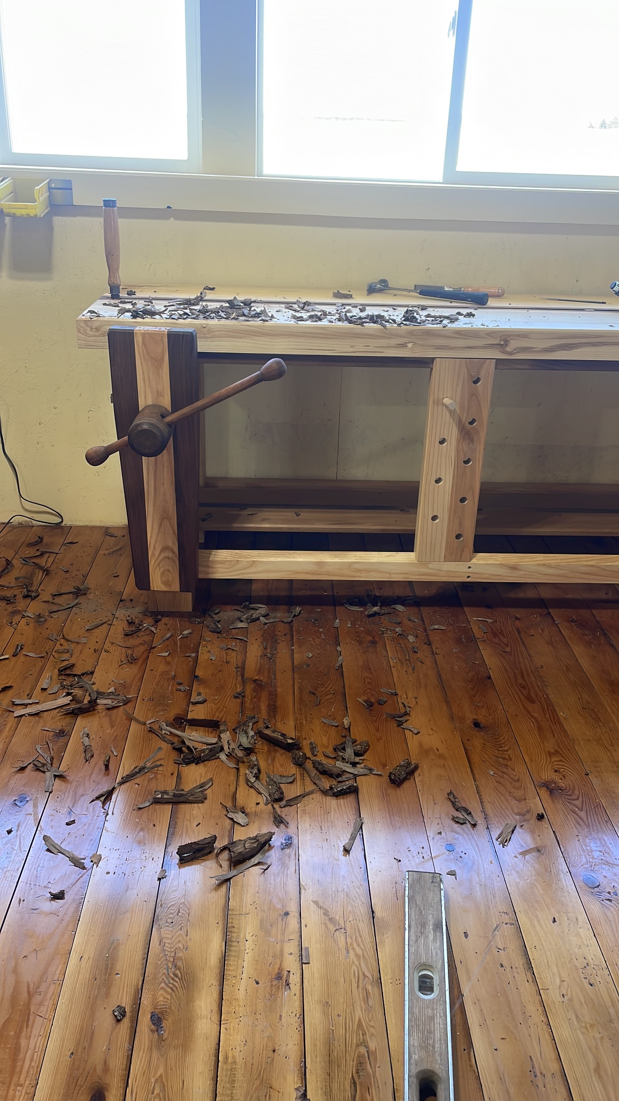 Hand plane and workbench surrounded by wood shavings during shop work.